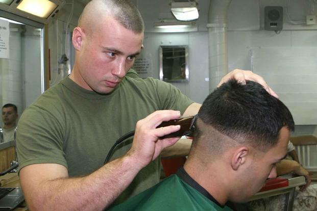 Sgt. Cole B. Nason gives a Marine a haircut.