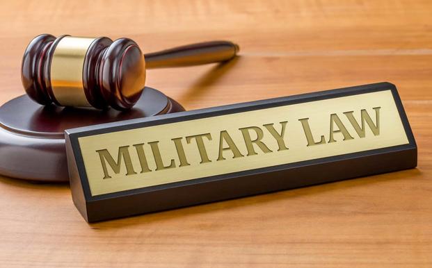 Image of gavel and placard reading military law