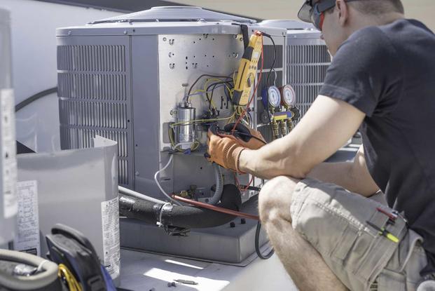 Man working on air conditioning compresser