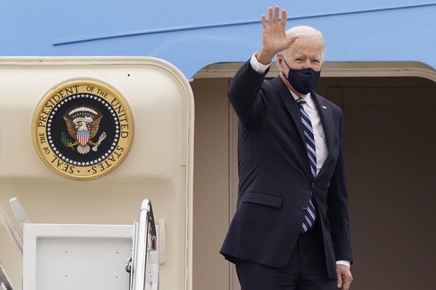 President Joe Biden waves from the top of the steps of Air Force One at Andrews Air Force Base