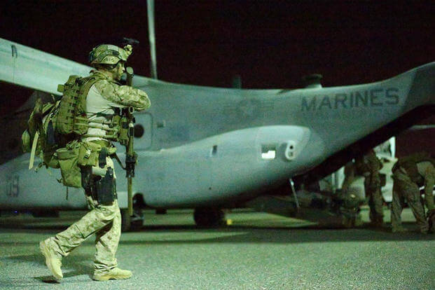 Marine reconnaissance man prepares to board an Osprey.