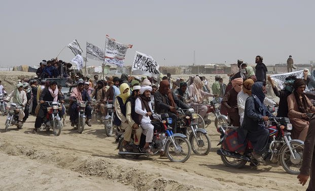 Supporters of the Taliban carry the Taliban's signature white flags