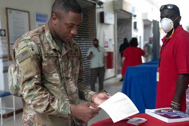 Soldier reads an absentee ballot at Camp Arifjan, Kuwait.