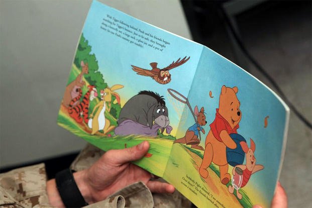 A Marine reads Winnie the Pooh book