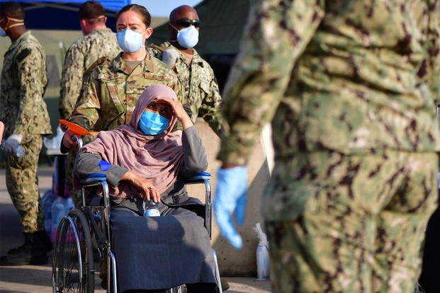 Senior Airman Romero assists an Afghan evacuee.