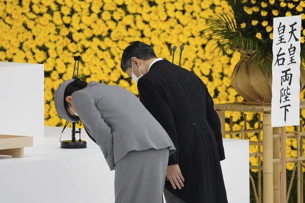 Japan's Emperor Naruhito, right, and Empress Masako bow during a ceremony.