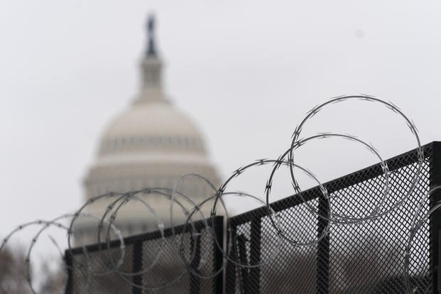 The U.S. Capitol is seen behind the razor fence 