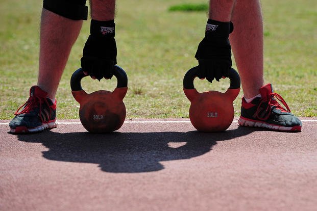 A participant in a new combat fitness class prepares to lift kettlebells.