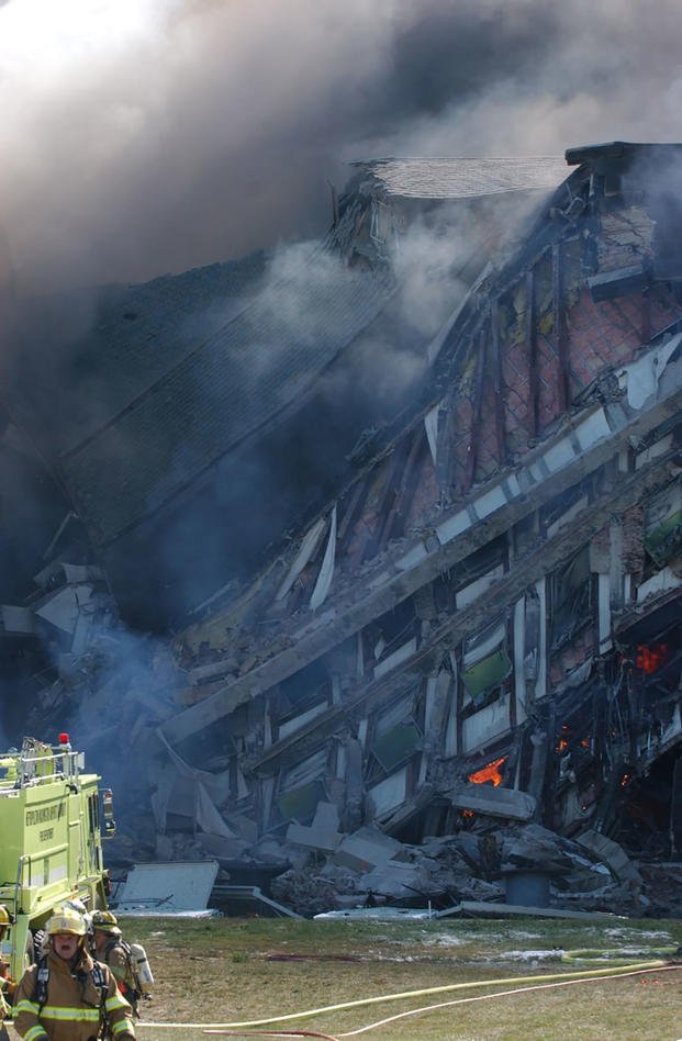 Fire crews work to put out the flames after the E Ring of the Pentagon collapsed, 11 September 2001