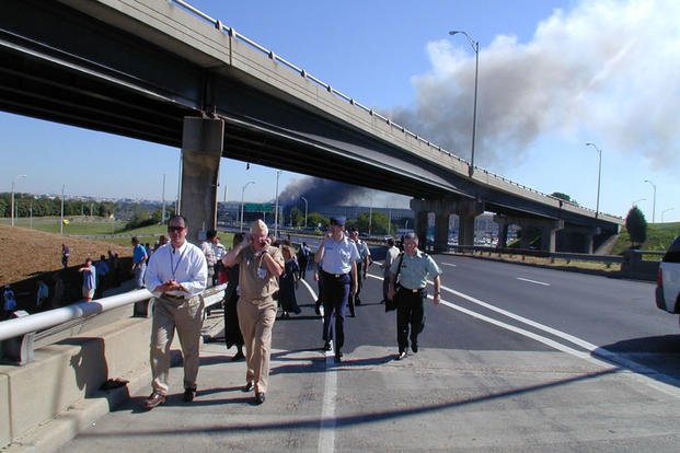 Pentagon employees walk away from the building along VA-27 S Washington Blvd following the attack, 11 September 2001.