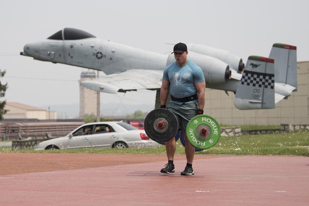 Soldier performs a farmer's walk during a strongest warrior competition.