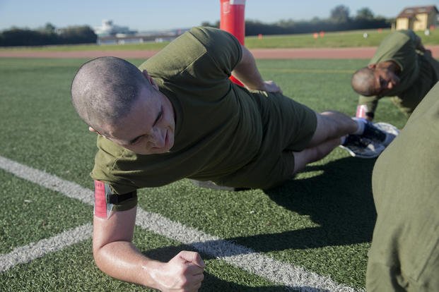 A Marine recruit performs side planks.
