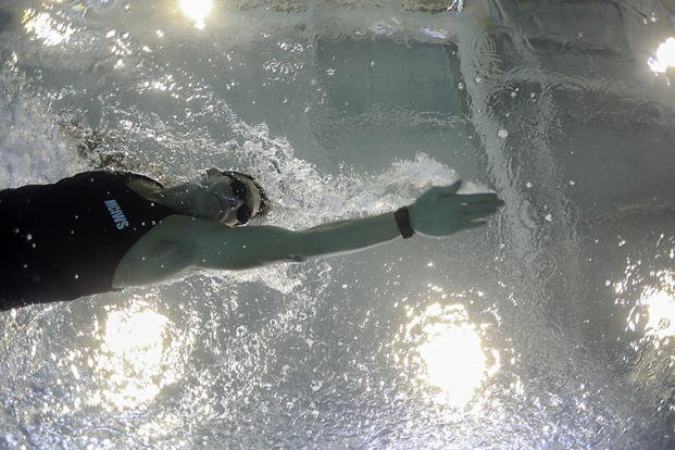 A Marine swims at a training pool.