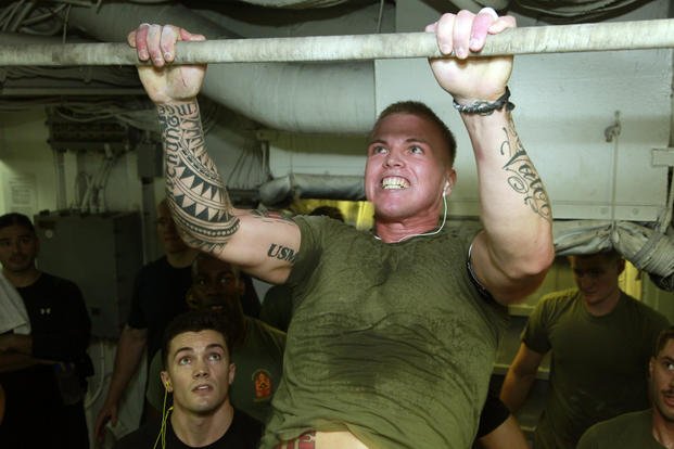 A Marine participates in a pull-up challenge.