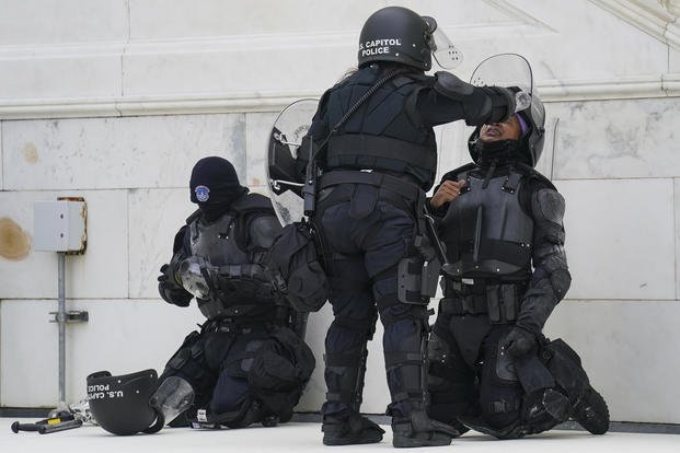 Police officer has eyes flushed after a confrontation with rioters at the Capitol 