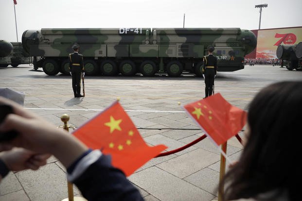 Spectators wave Chinese flags as military vehicles carry DF-41 ballistic missiles 