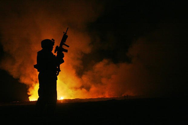 A burn pit lights up the night sky in Camp Fallujah, Iraq.