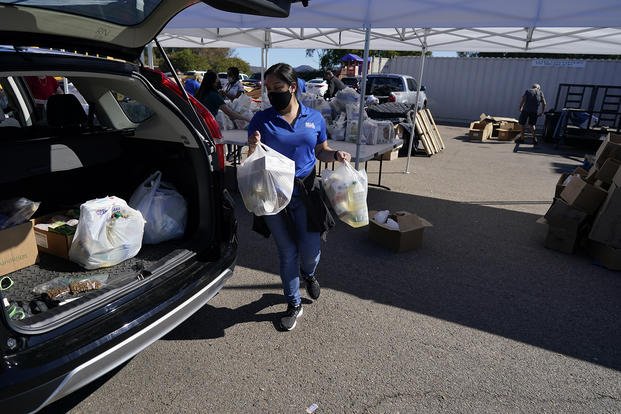 A volunteer loads food into a car at an Armed Services YMCA food distribution.
