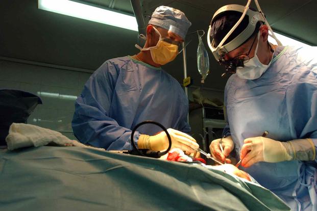 Two surgeons perform an operation on an Iraqi citizen