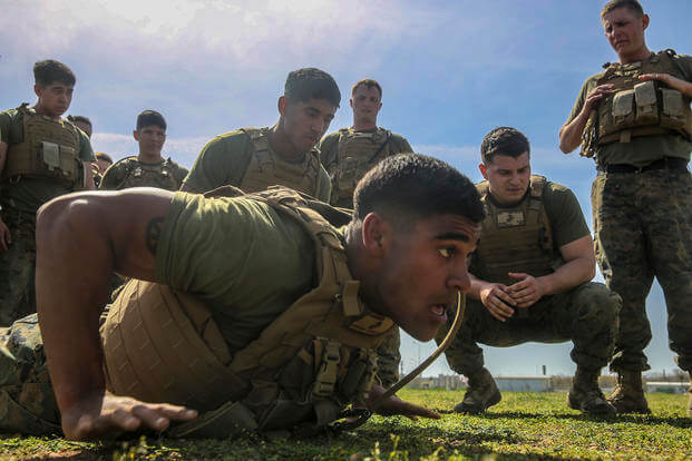 A Marine motivates his platoon during a push-up competition.