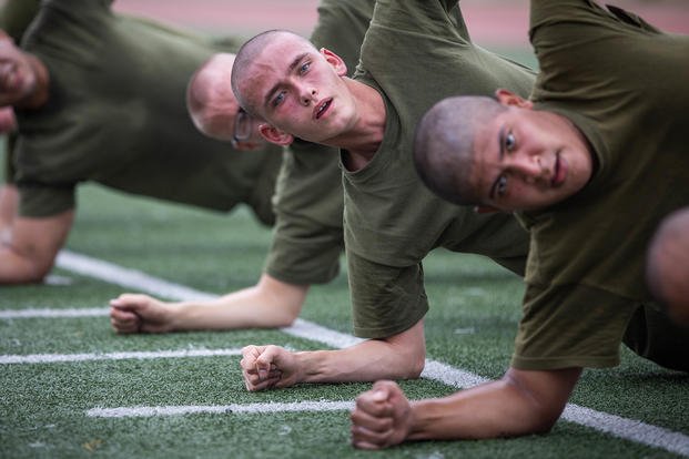 Marine recruits perform side planks.