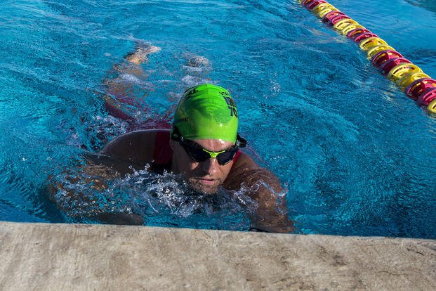 Navy lieutenant finishes a 200-meter swim during a swim meet.