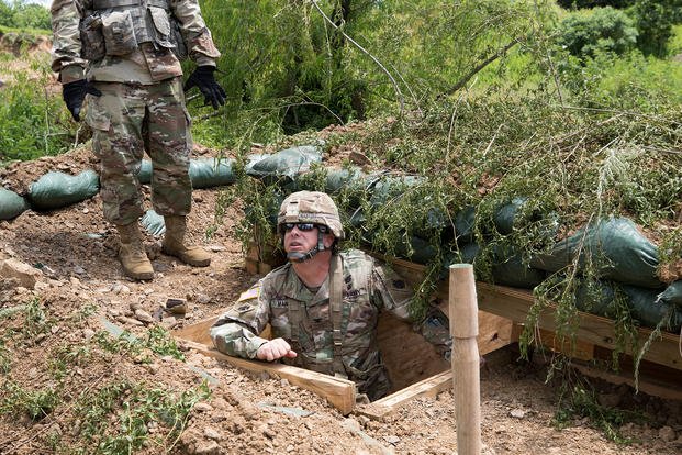 An Oklahoma Army National Guardsman inspects a fighting position.