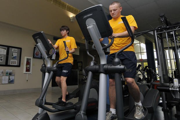 Sailors work out on elliptical machines.