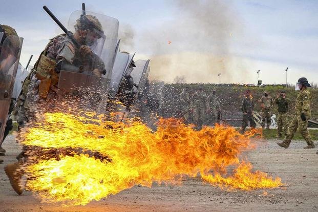 Iowa Army National Guardsmen run through a spray of gasoline and flames during fire phobia training at Camp Novo Selo, Kosovo.