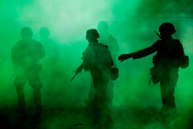 Marines with Company A, 1st Battalion, 7th Marine Regiment, use green smoke to provide concealment