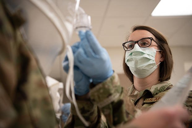 Oklahoma Air National Guard Tech. Sgt. Rebecca Keylon sprays saccharine solution into a qualitative fit test hood during an N95 mask fit test. 
