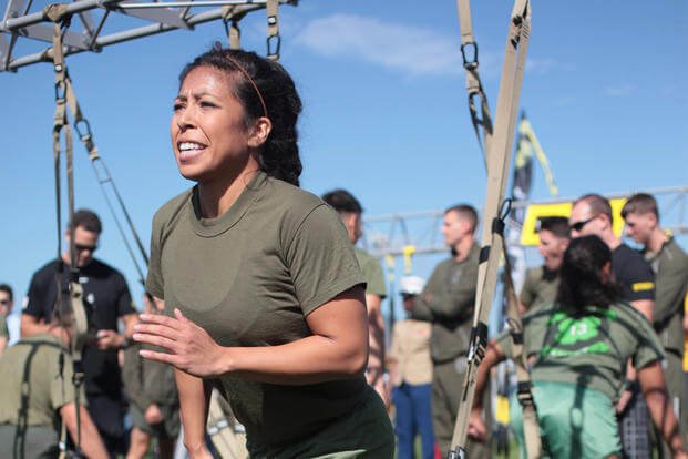 A first lieutenant performs lunges using the TRX suspension system.