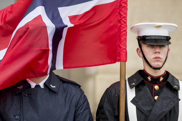 Norwegian flag flies in the face of a member of the military
