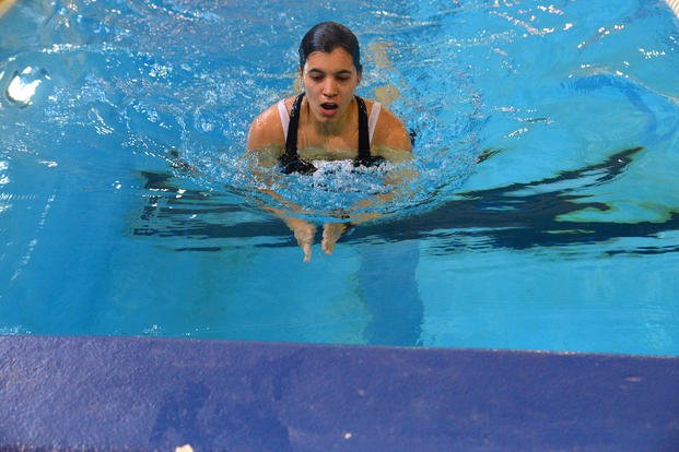 A student testing to be qualified as a second-class swimmer utilizes her breaststroke.