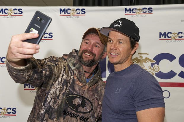 A fan takes a selfie with actor and entrepreneur Mark Wahlberg during a meet-and-greet at Quantico.