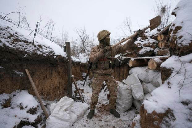 Ukrainian serviceman cleans his position in a trench on the front line in the Luhansk region
