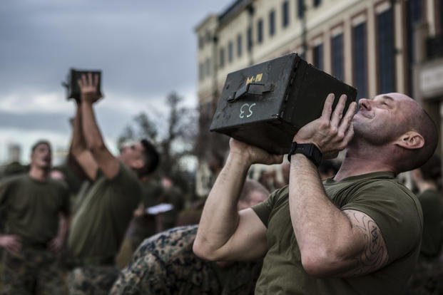 Marines perform ammo can lifts during a combat fitness test.