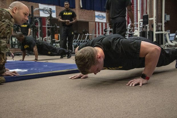 An officer candidate grinds to complete the push-up portion of the Army physical fitness test.