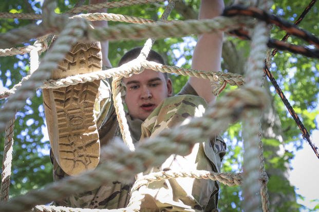 An Army Reserve soldier climbs a rope ladder during an obstacle course.