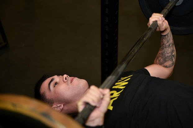 An Army paratrooper bench-presses during Soldier Performance Education for Advanced Readiness and Resilience (SPEAR) training.