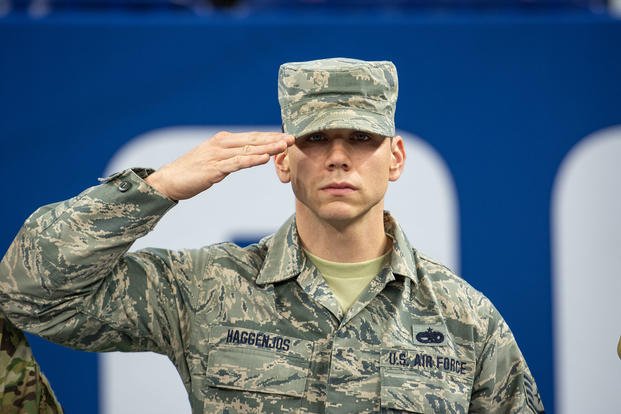 An airman salutes during ceremonies at Lucas Oil Stadium in Indianapolis. 
