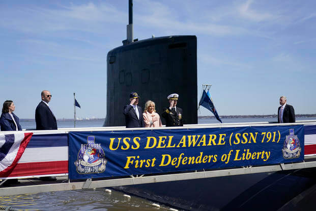 President Joe Biden stands with first lady Jill Biden before they board the USS Delaware.