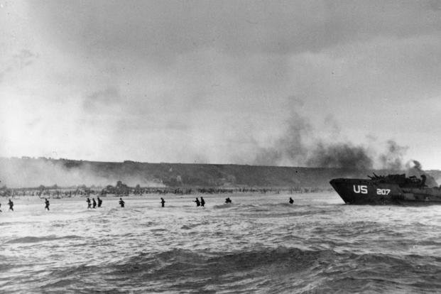 U.S. infantrymen wade ashore during the initial Normandy landing operations in France.
