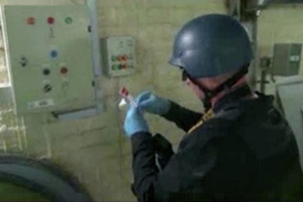 This file image made from video broadcast on Syrian StatA chemical weapons expert purportedly takes samples at a chemical weapons plant in Syria.