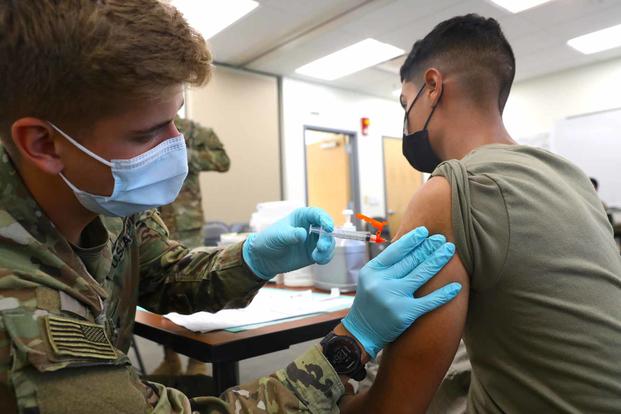 Spc. Tyler Boyer administers the COVID-19 vaccine at Fort Carson.