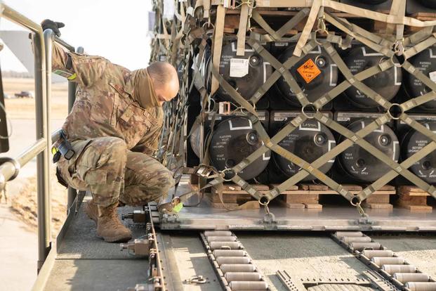 Airman loads ammunition, weapons and other equipment bound for Ukraine.