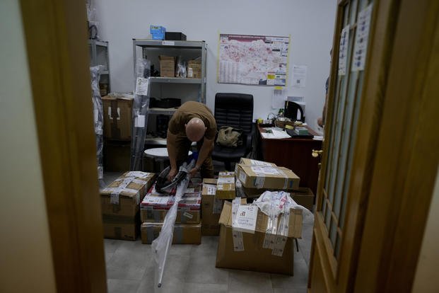 volunteer prepares boxes of goods to be delivered to soldiers