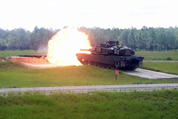 An M1A2 Abrams rank fires its main gun during a demonstration.