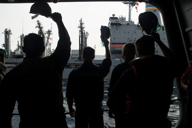 Sailors wave good-bye to the Military Sealift Command fleet replenishment oiler USNS Guadalupe