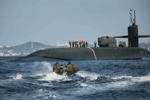 U.S. Marines in combat rubber raiding craft approach USS Ohio.